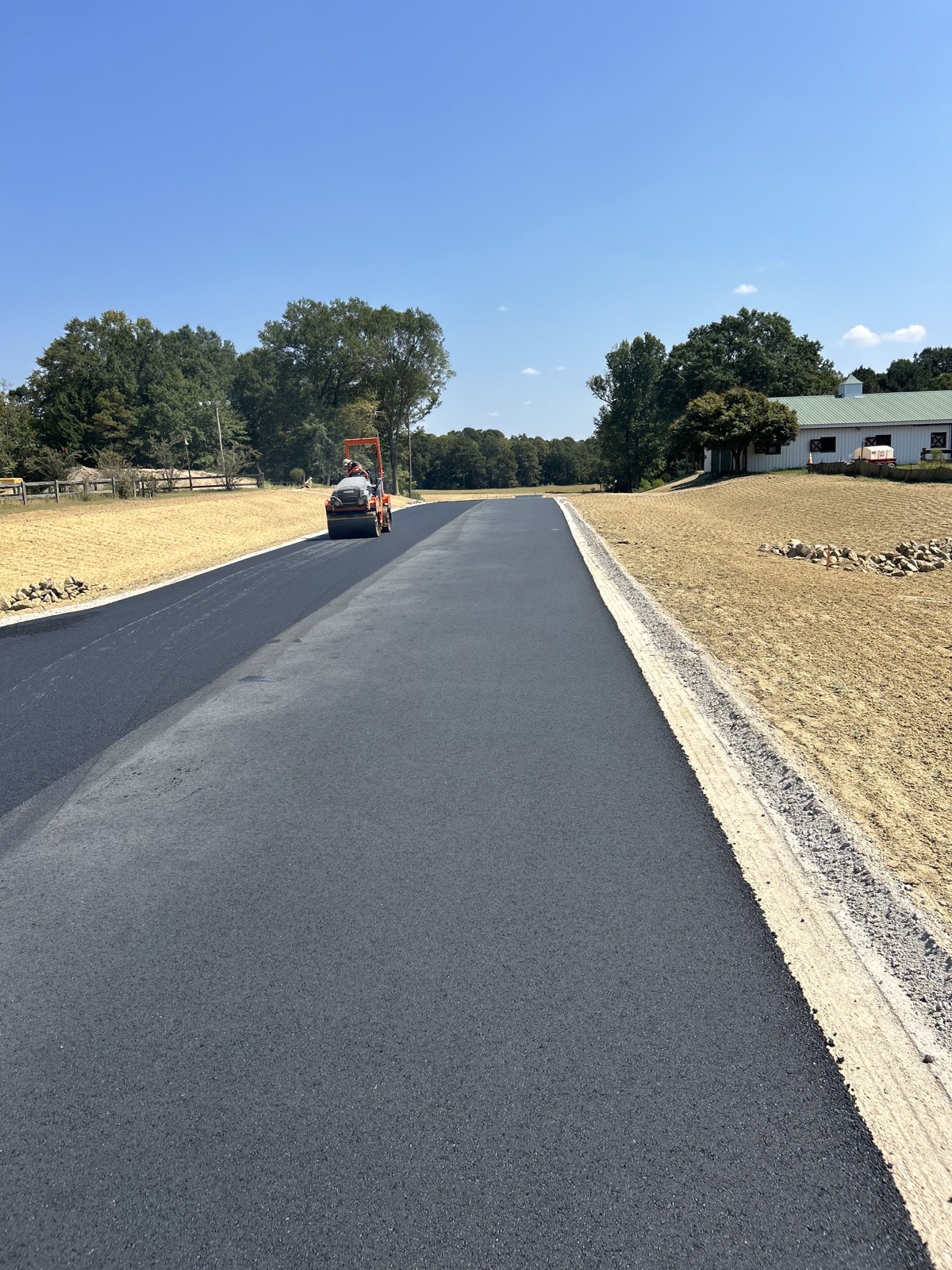 Roller compacting a newly paved private drive