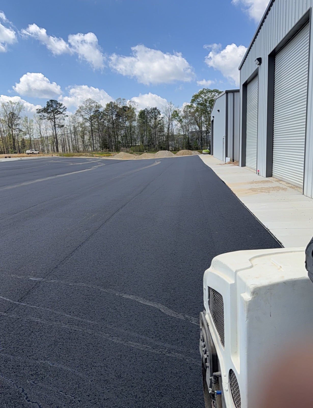 Fresh commercial asphalt surface beside a storage facility