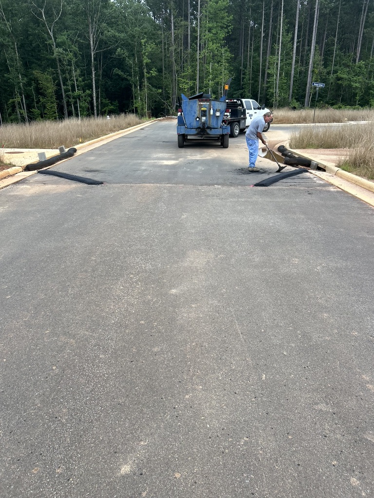 Ford Paving crew applying sealer on a neighborhood street