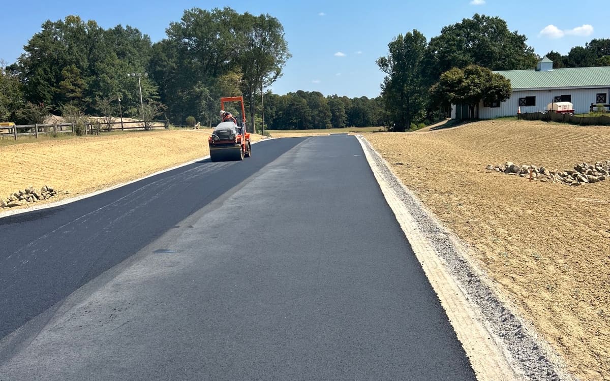 Roller compacting a freshly paved private drive on a Central Alabama property