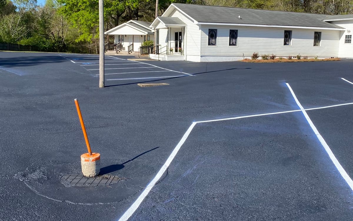Completed church parking lot with fresh sealer and crisp white striping